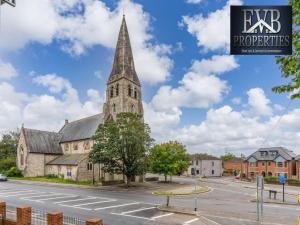 une vieille église avec une grande cloche dans une rue dans l'établissement Stylish Southampton Abode, à Southampton