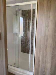a shower in a bathroom with a glass cabinet at holidayhome-romneysands holiday park in Littlestone-on-Sea