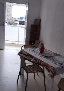 a dining room table with chairs and a plate on it at Casa para temporada, Centro de Ubatuba in Ubatuba