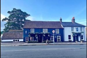 een blauw-wit gebouw op de hoek van een straat bij Kings Arms in Egham