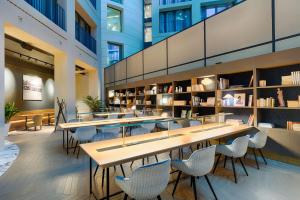 a library with tables and chairs in a building at Radisson Collection Hotel, Berlin in Berlin