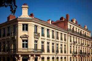 un grand bâtiment blanc avec une tour en haut dans l'établissement Hotel De Cambis, à Avignon