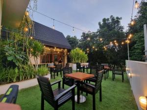 un patio con tavoli, sedie e luci di Onesouth Boutique Hotel Pulau merah a Banyuwangi