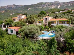 a villa with a swimming pool and mountains in the background at Resort "Maslinjak" in Budva