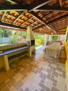 an outdoor patio with a fireplace and a wooden roof at Sonho meu Ilhabela - 50m da Praia do Julião in Ilhabela