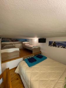 una piccola camera con 2 letti e una TV di Lime Apartments - LIDO ad Alghero