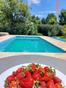 a plate of strawberries on a table next to a swimming pool at Puerta 1910 in Tunuyán