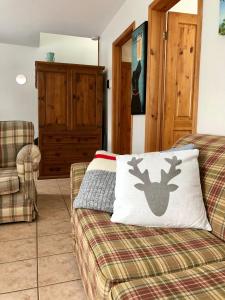 a living room with a couch with a reindeer pillow on it at Chalet du Ruisseau in Sainte-Germaine-du-Lac-Etchemin