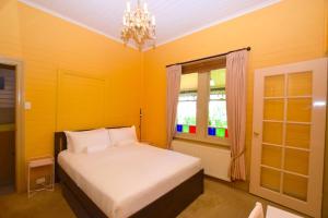 a yellow bedroom with a bed and a window at Mary Villa in Katoomba