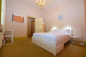 a bedroom with a large white bed and a chandelier at Mary Villa in Katoomba
