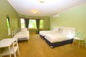 a bedroom with two beds and a table and a desk at Mary Villa in Katoomba