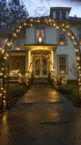 Herkimer的住宿－Raindrops On Roses Bed & Breakfast，房屋前有圣诞灯的拱门