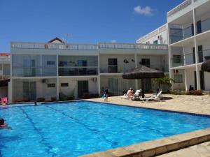 a swimming pool in front of a building at Apto Praia do Amor 2 quatos in Conde