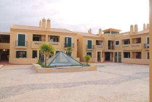 a building with a fountain in the middle of a courtyard at Vila Bairos Apartment Vilamoura in Vilamoura