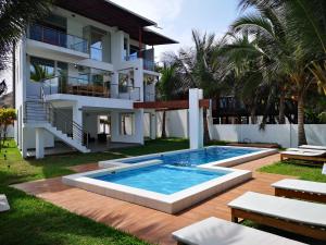 a house with a swimming pool in front of a house at Casa de Mateo - Zorritos - Tumbes in Zorritos