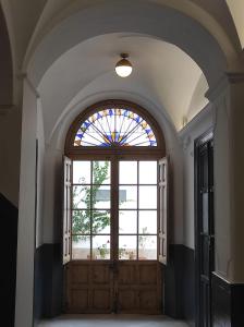 梅里達的住宿－PETRONILA 1881，一个大木门,有彩色玻璃窗