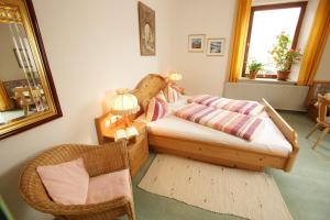 a bedroom with a bed and a chair and a window at Gästehaus Ethiko in Ettal