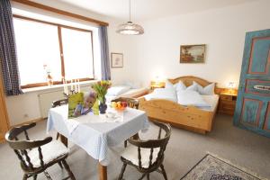 a living room with a table and a bed at Gästehaus Ethiko in Ettal