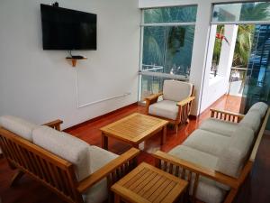 uma sala de estar com cadeiras e uma televisão de ecrã plano em Casa de Mateo - Zorritos - Tumbes em Zorritos