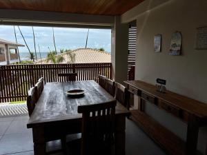 een eetkamer met een houten tafel en stoelen bij Apto novo Imperia Lounge pé-na-areia Itacimirim in Itacimirim