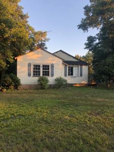 a small white house with a yard and trees at Private Cottage in Rural Clemmons in Clemmons