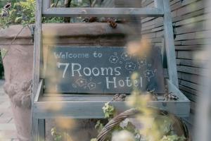 a welcome to rooms hotel sign in a window at 7 Rooms Hotel & Cafe - デザイナーズホテル - 30mins from Disneyland in Tokyo