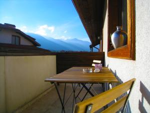 a table on a balcony with a view of mountains at Solar nest with fireplace and panoramic view 700m from skilift and centrum in Bansko