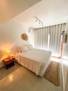 a bedroom with a white bed and a window at Pousada Brisa Mar in Fernando de Noronha