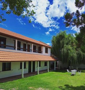 um edifício com um quintal com cadeiras e árvores em Sauce Viejo em Mina Clavero