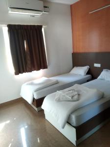 a room with two beds in a hotel room at Dunhill Premium Service Apartment in Bangalore