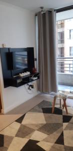 uma sala de estar com uma televisão de ecrã plano e uma janela em Departamento Comuna Providencia, cercano metro Los Leones y Pedro de Valdivia em Santiago
