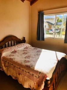 a bed sitting in a bedroom with a window at La posada de Icha in El Bolsón