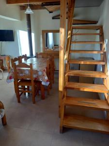 a dining room with a table and a wooden ladder at La posada de Icha in El Bolsón +18 photos