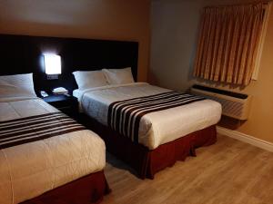 a hotel room with two beds and a window at Silver Maple Motel in Haliburton