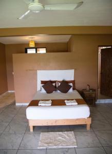 a bedroom with a large bed with two towels on it at Beach Front Guesthouse in Puerto Escondido