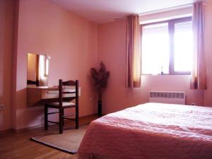 a bedroom with a bed and a desk and a chair at Solar nest with fireplace and panoramic view 700m from skilift and centrum in Bansko