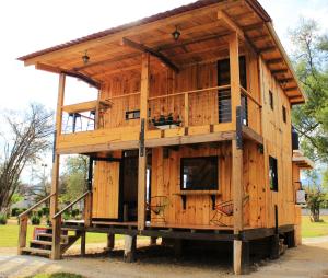 una grande casa in legno con balcone su una piattaforma di Tiny House with trekking circuit a San Cristóbal de Las Casas