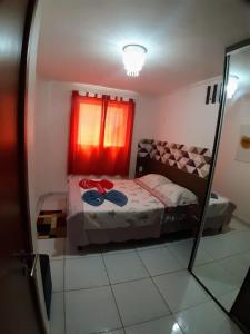 ein Schlafzimmer mit einem Bett und einem Spiegel in der Unterkunft Apartamento no Bessa in João Pessoa + 10 Fotos