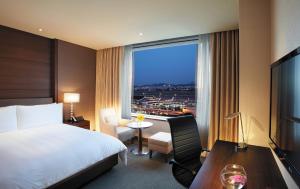 a hotel room with a bed and a large window at LOTTE City Hotel Gimpo Airport in Seoul