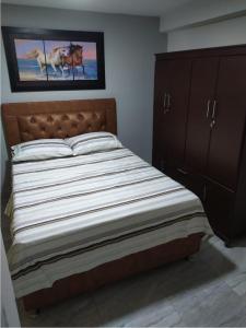 ein Bett in einem Schlafzimmer mit einem Bild von Pferden in der Unterkunft Piso 2-apartment near to Cali Airport in Palmira