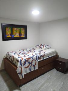 a bedroom with a bed with a comforter on it at Piso 2-apartment near to Cali Airport in Palmira