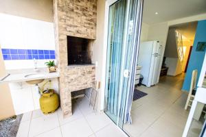 a kitchen with a stone fireplace in a room at Casa de praia a 200 metros do mar in Florianópolis +71 photos