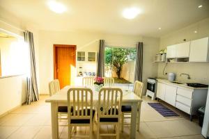 a kitchen with a table and chairs in a kitchen at Casa de praia a 200 metros do mar in Florianópolis