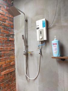 une douche avec un distributeur de savon sur un mur dans l'établissement Villa Mak Intan, Che'Pa Village Langkawi, à Kuah