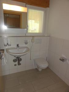 ein Badezimmer mit Waschbecken und Toilette in der Unterkunft Welcome Hotel Täsch by Täscherhof in Täsch + 21 Fotos