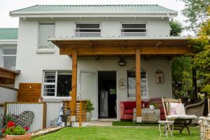 a wooden pergola on a white house at The Khaya Accommodation for the Soul in Lorraine