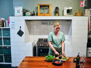 Eine Frau, die in einer Küche steht und Essen zubereitet. in der Unterkunft Black Diamond Lodge in Collie