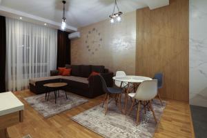 ein Wohnzimmer mit einem Sofa und einem Tisch in der Unterkunft Apartment Promenada Avenija in Novi Sad