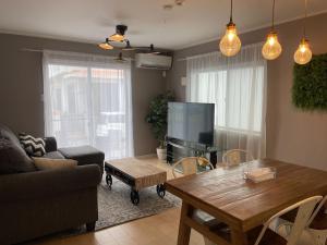 a living room with a table and a television at Condominium Palace Resort Chatan II in Chatan