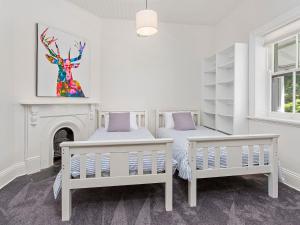 um quarto com 2 camas e uma lareira em Merioola Retreat em Gerringong
